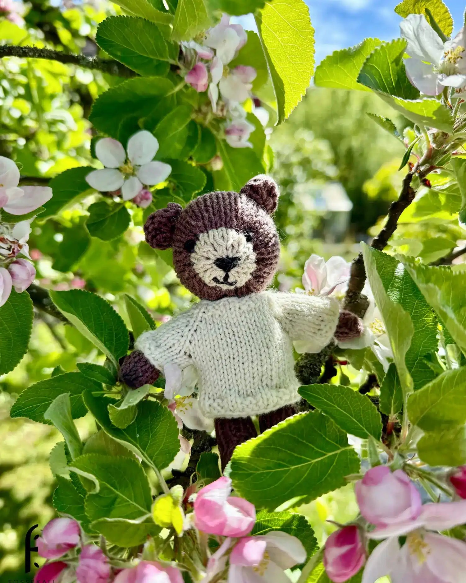 Knitted teddy bear in a tree.