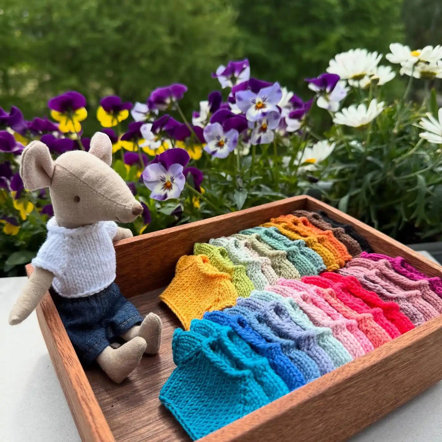 Stuffed mouse with knitted shirts.